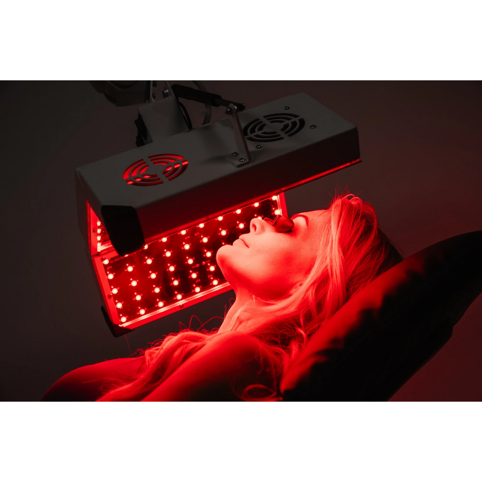 Body Balance System ApolloGLOW Red & Infrared Light Panel – red LED panel close-up over a woman's face