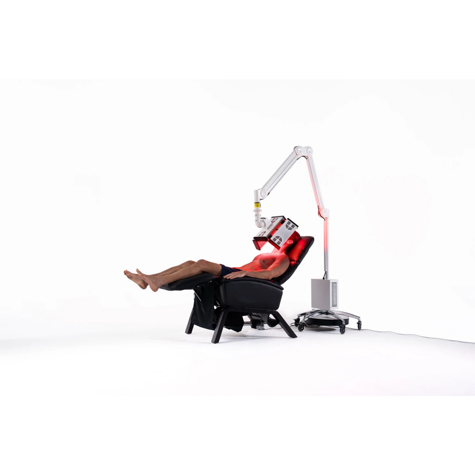 Body Balance System ApolloGLOW Red & Infrared Light Panel – woman reclining in a chair under the red light panel
