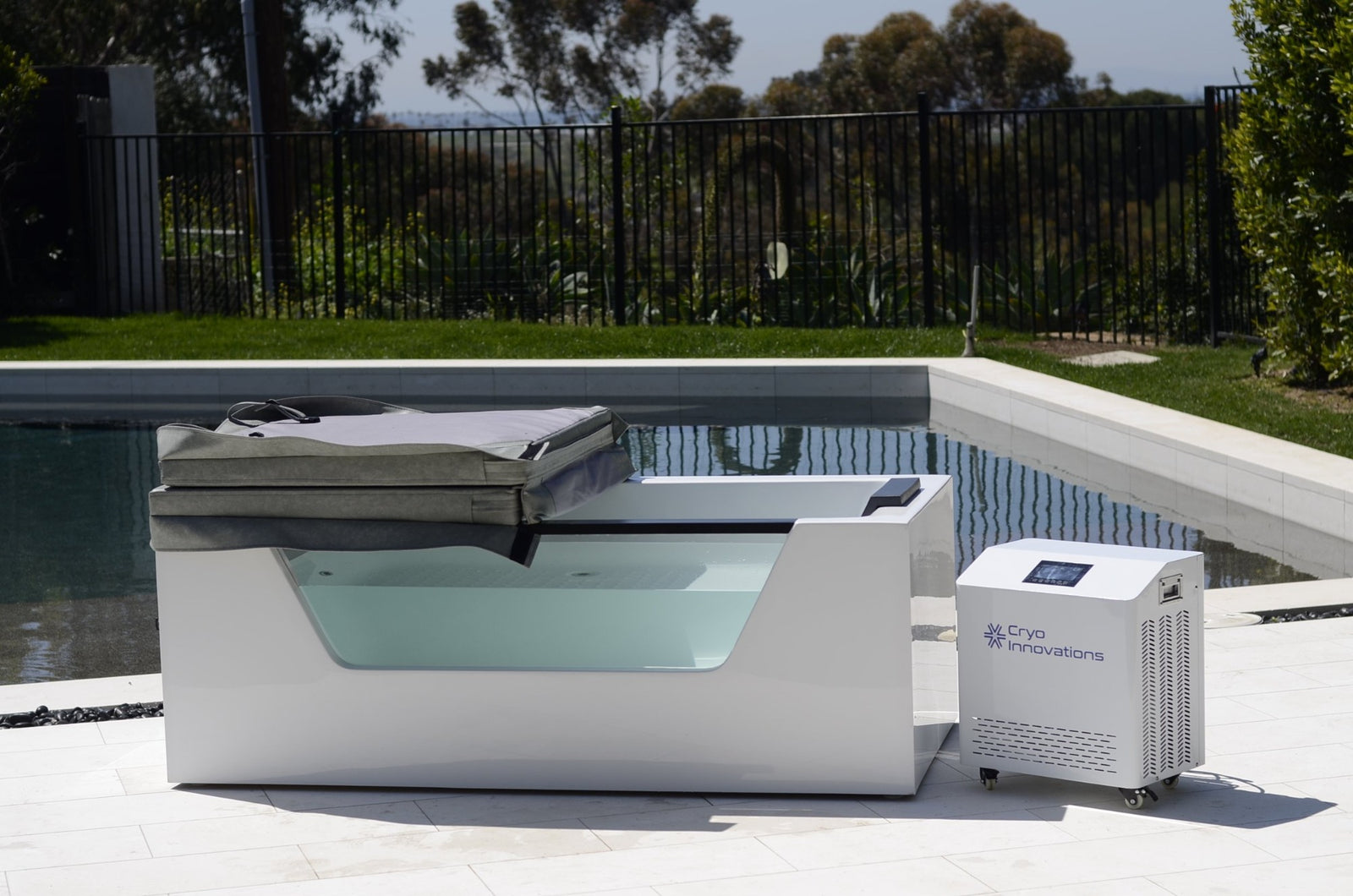 Cryo Innovations XR Cryo Plunge with Window acrylic tub with a cover and chiller/heater beside a pool