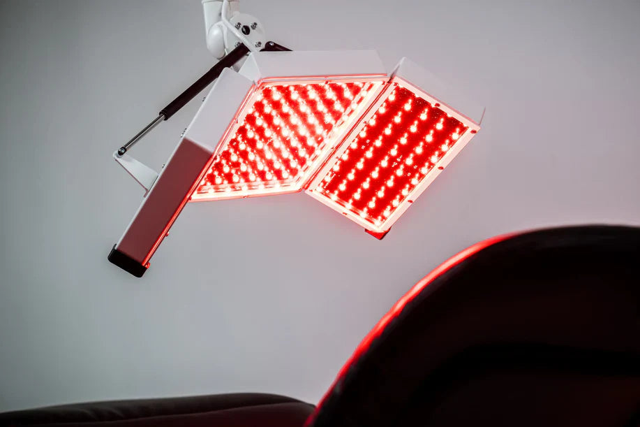 Red light therapy panels glowing above treatment bed
