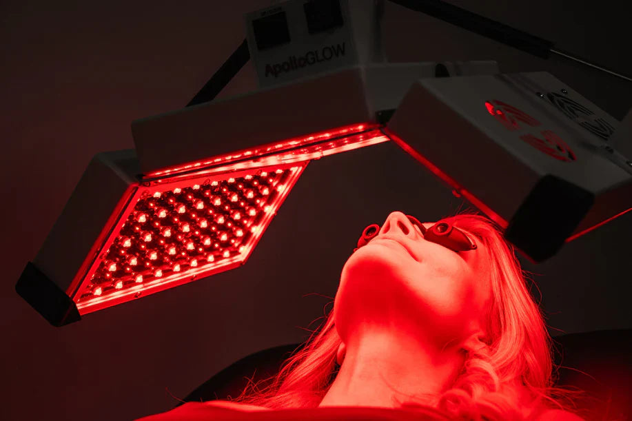 Woman receiving red light therapy on face using ApolloARC panel