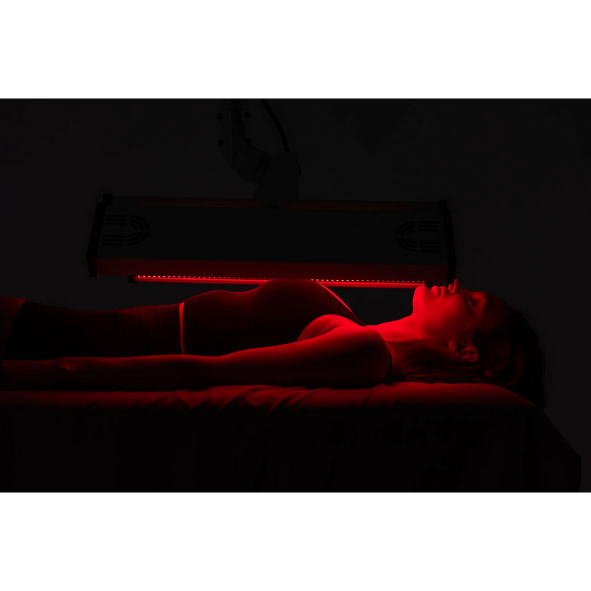 Body Balance System ApolloARC Red & Infrared Light Panel – woman lying under a horizontal red light panel