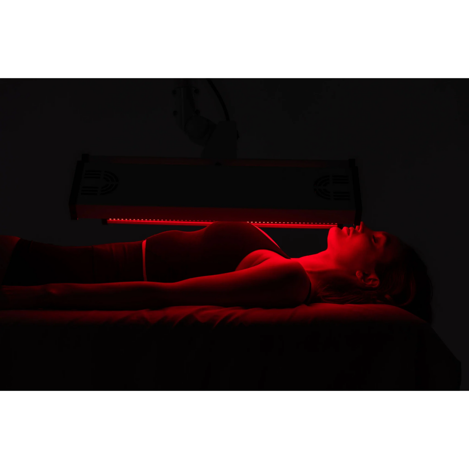 Body Balance System ApolloARC Red & Infrared Light Panel – woman lying under a horizontal red light panel