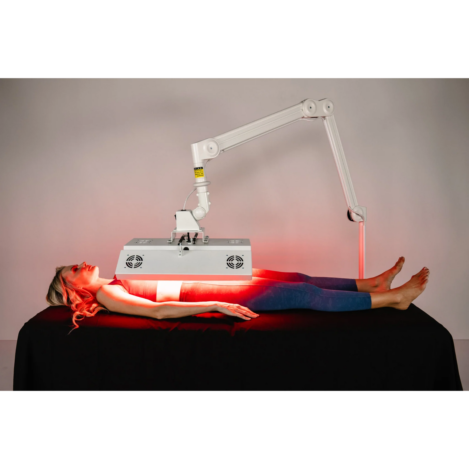 Body Balance System ApolloARC Red & Infrared Light Panel – woman lying under the panel on a treatment table