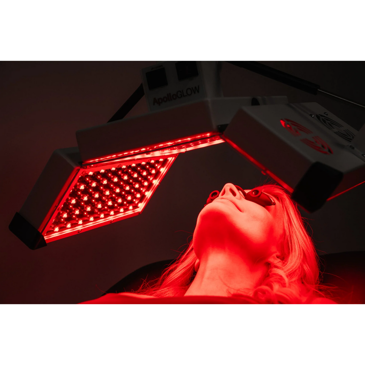 Body Balance System ApolloGLOW Red & Infrared Light Panel – red LED panel angled over a woman's face