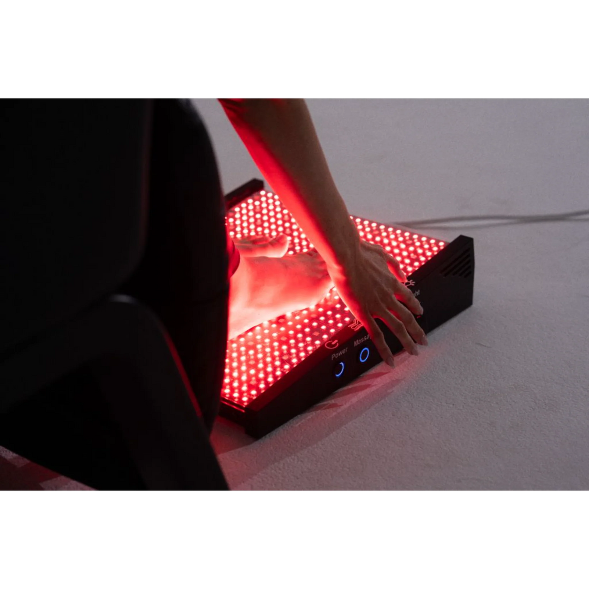 Body Balance System Foot Revitalizer Red &amp; Infrared Light Device – hand on the glowing red foot panel
