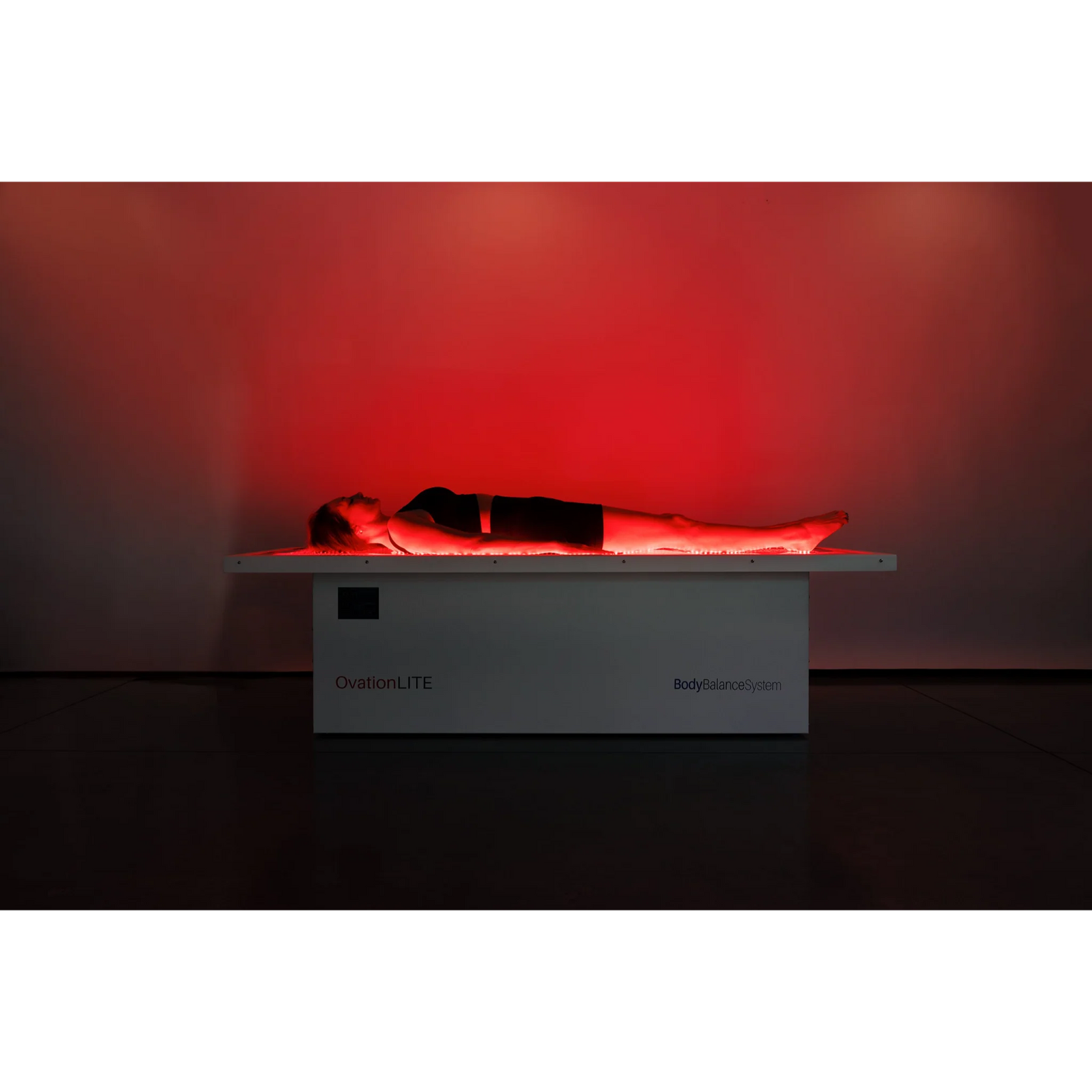 Body Balance System OvationLITE Zero Gravity Red & Infrared Light Bed – person lying on the bed under red light