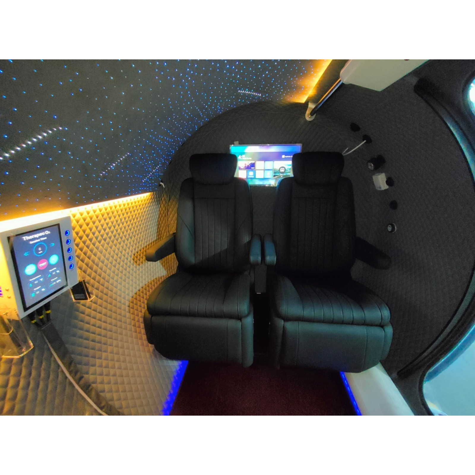 Macy-Pan HE5000 Plus Multiplace Hard-Shell Hyperbaric Chamber – interior with black seats and a TV