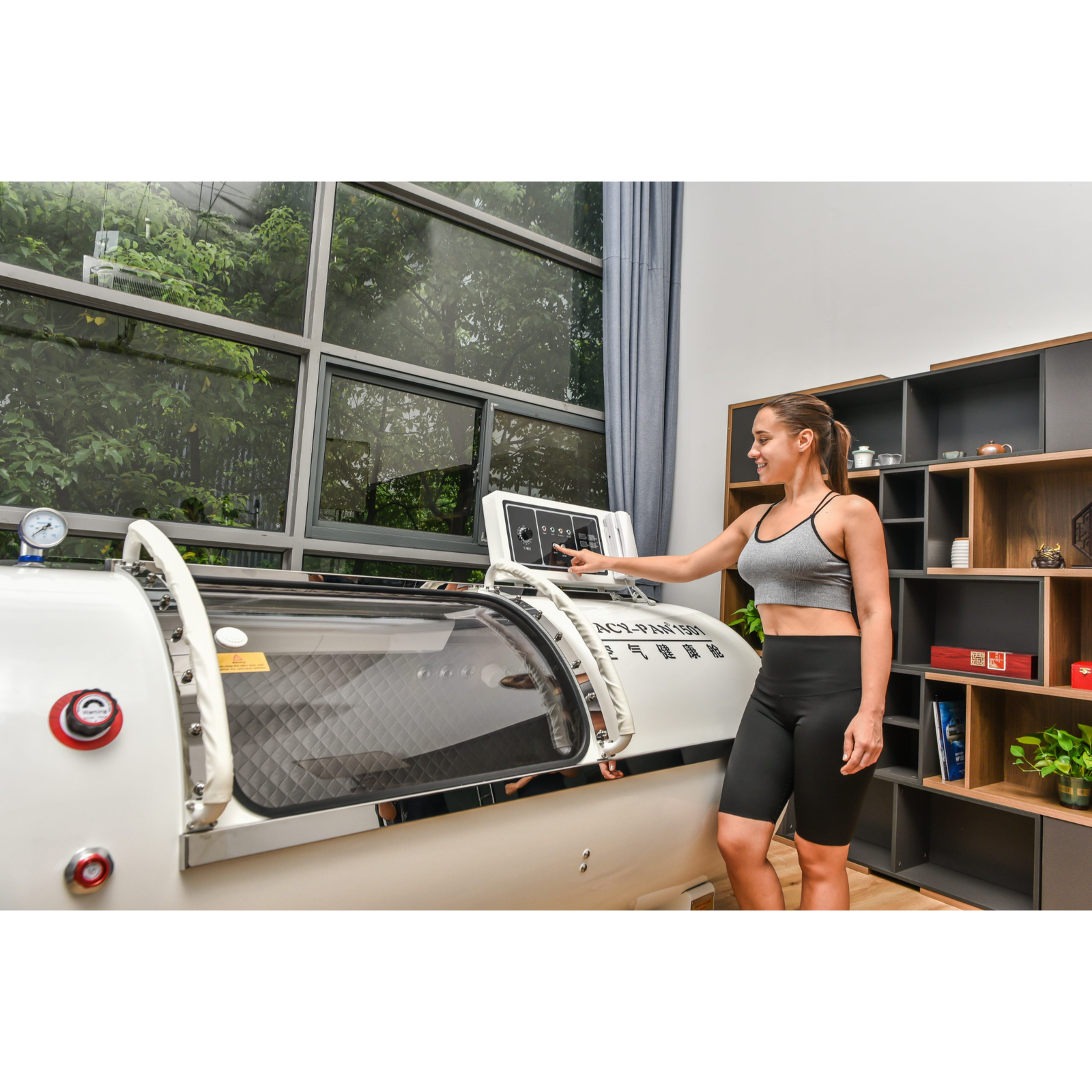 Macy-Pan HP1501 Hard-Shell Lying Hyperbaric Chamber – woman using the touch panel beside the chamber