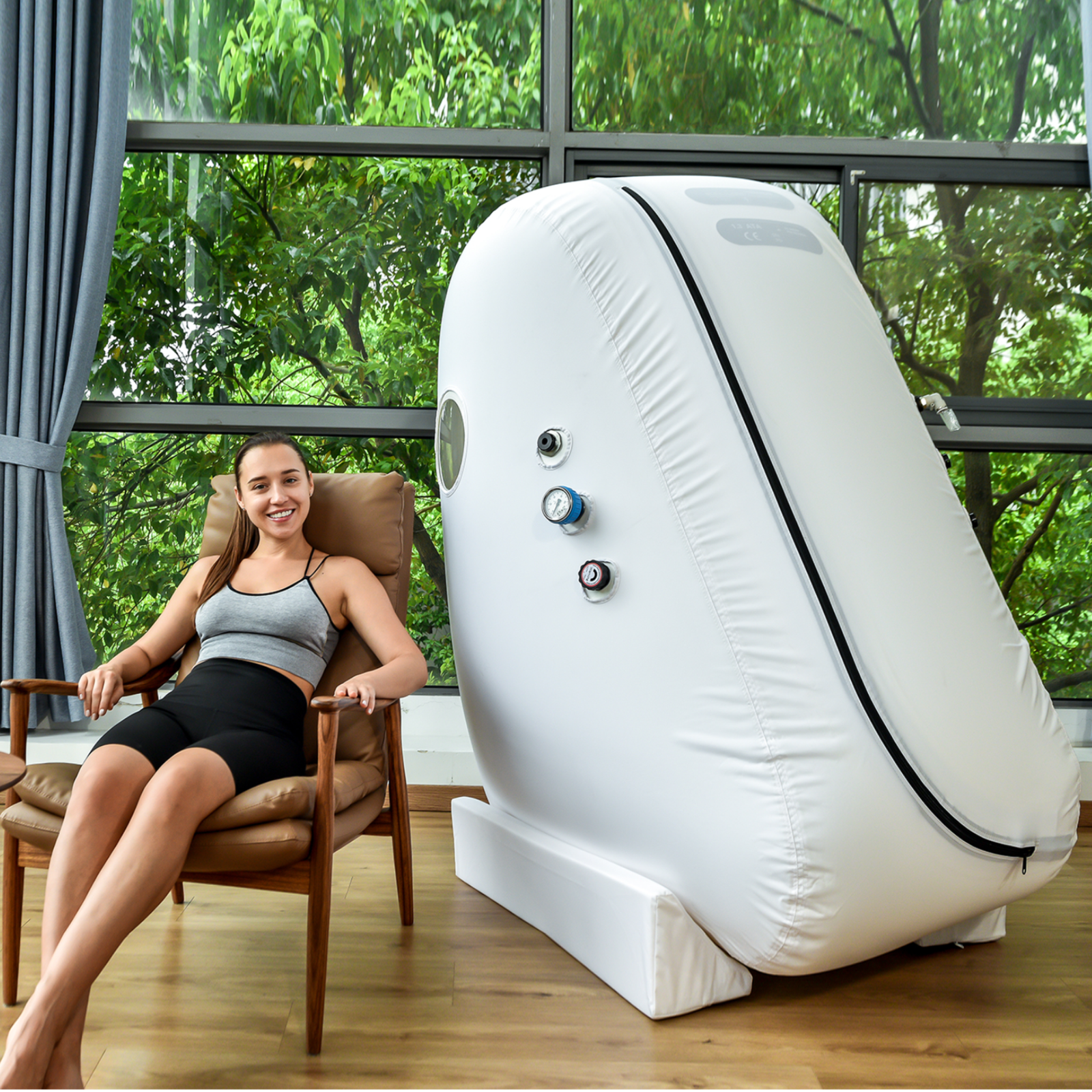 Macy-Pan L1 Sitting Hyperbaric Chamber – woman sitting in a chair by the chamber