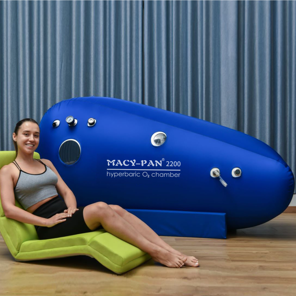 Macy-Pan ST2200 Sitting Hyperbaric Chamber – woman on a folding chair by the chamber