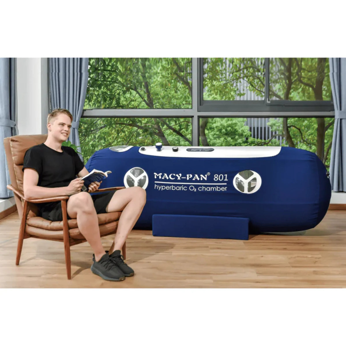 Macy-Pan ST801 Soft Lying Hyperbaric Chamber – man sitting beside the chamber