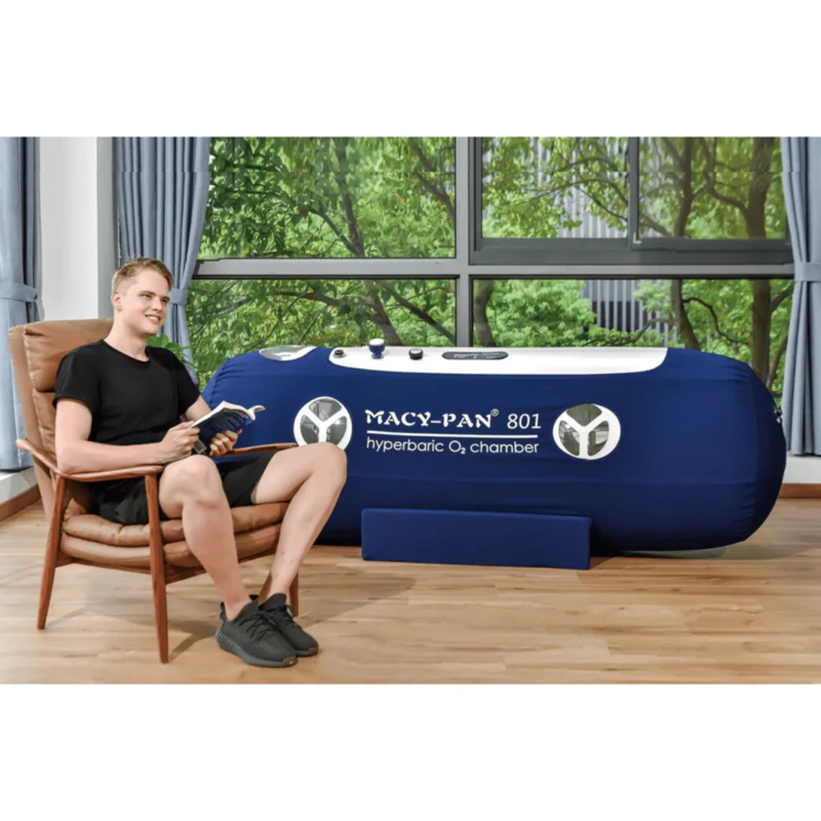 Macy-Pan ST801 Soft Lying Hyperbaric Chamber – man sitting beside the chamber