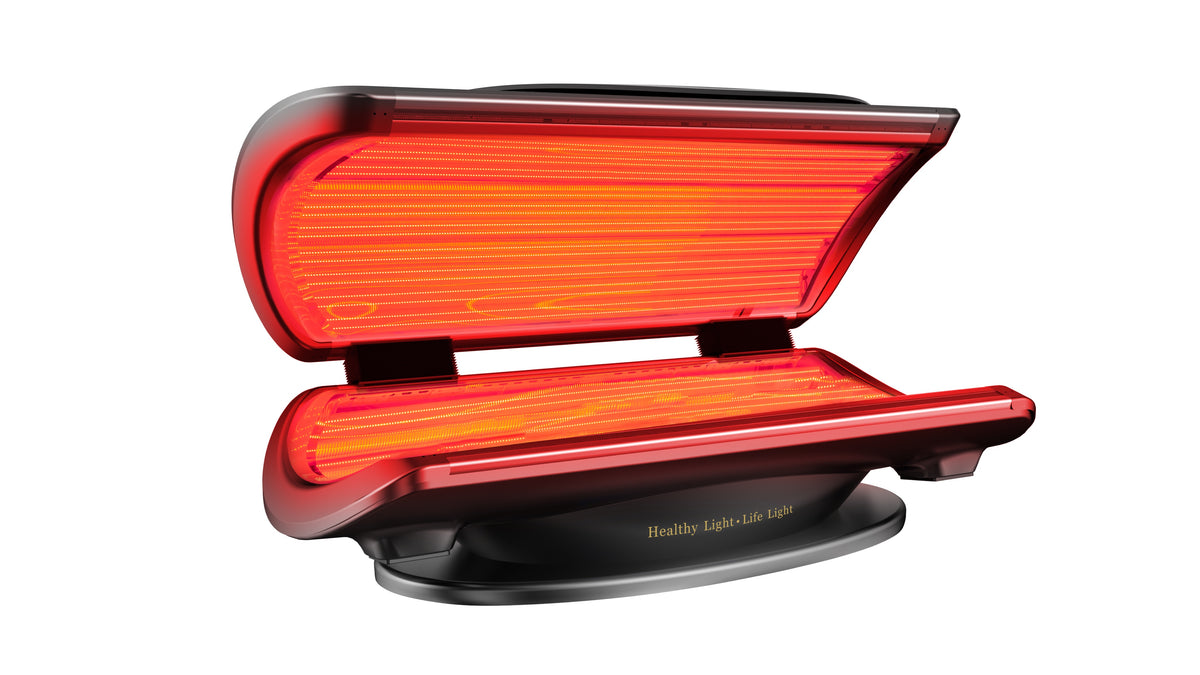 Merican MMB Plus whole-body red light therapy bed in Crystal Black, canopy open with red light on, angled view