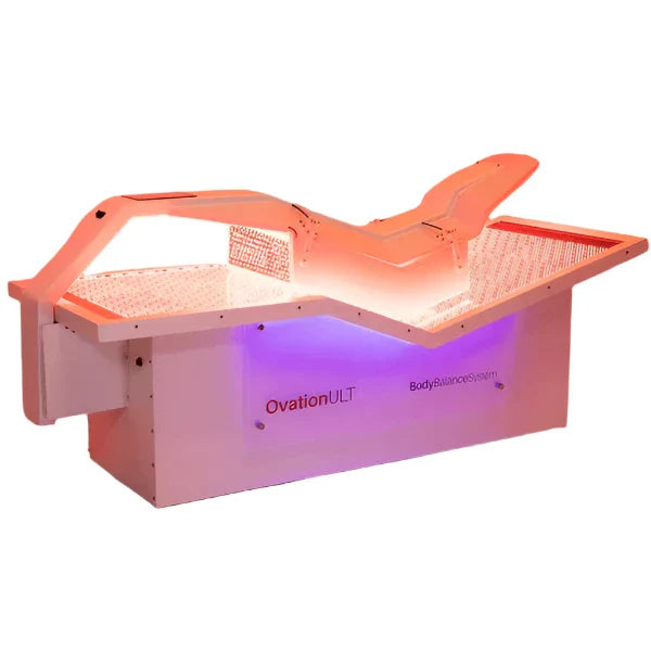 Side angle view of OvationULT red light therapy bed with LEDs illuminated and canopy partially open
