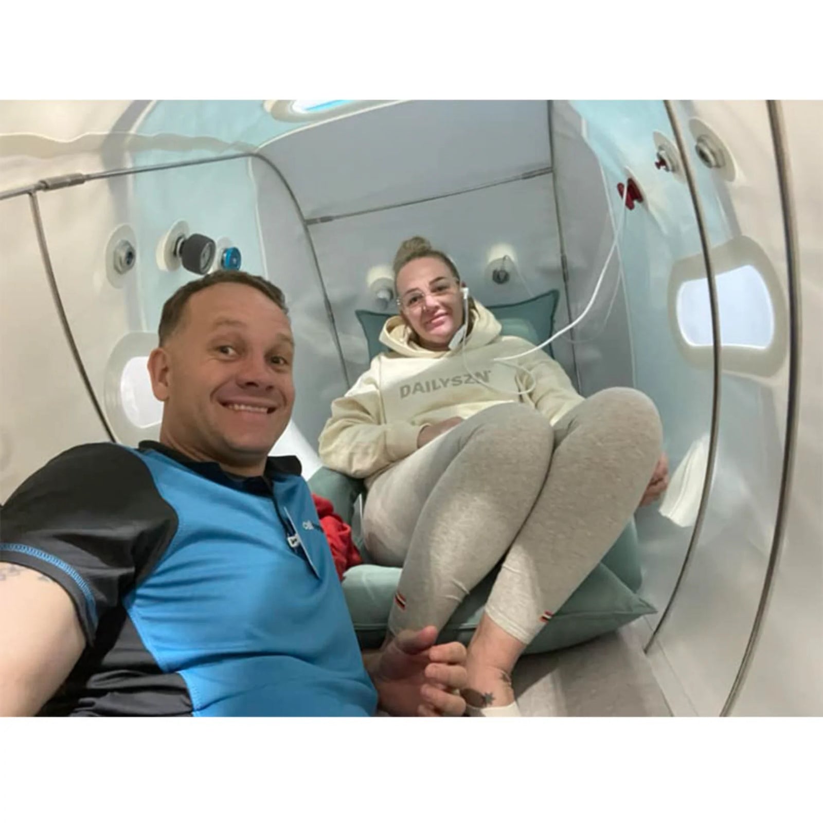 OxyRevo Forward90 MINI Portable Sitting Hyperbaric Chamber – two people smiling inside the chamber