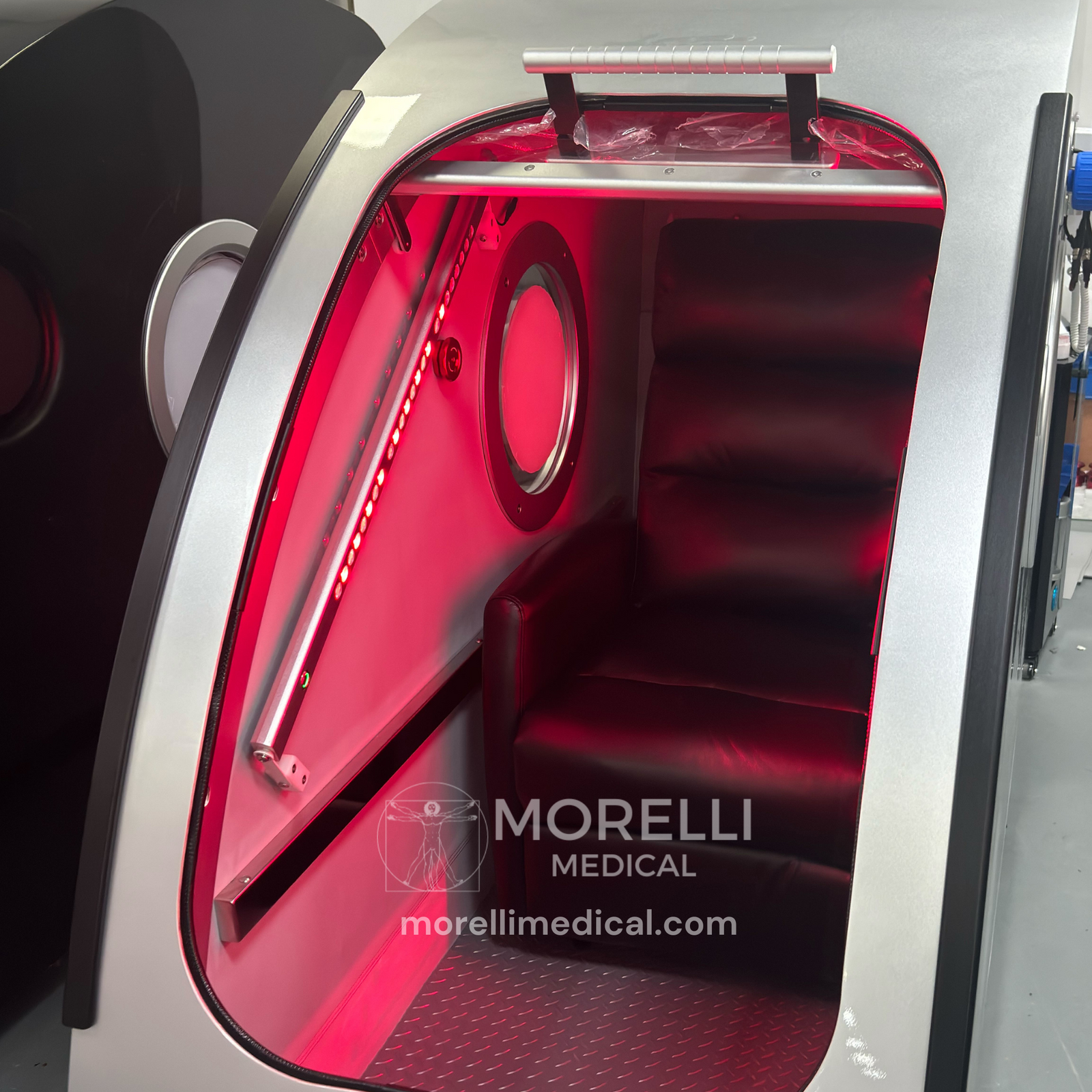 OxyRevo Space60 Hard-Shell Sitting Hyperbaric Chamber – red light glowing inside the chamber