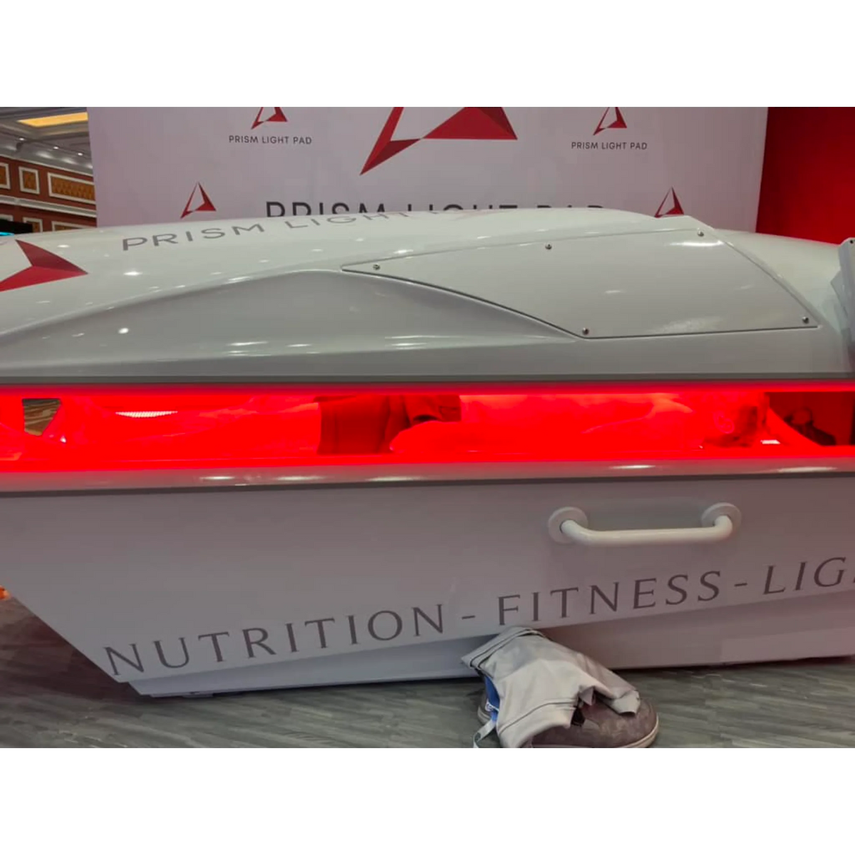 Prism Light Pod Full-Body Red Light Therapy Bed – pod open with red light on a lit stage