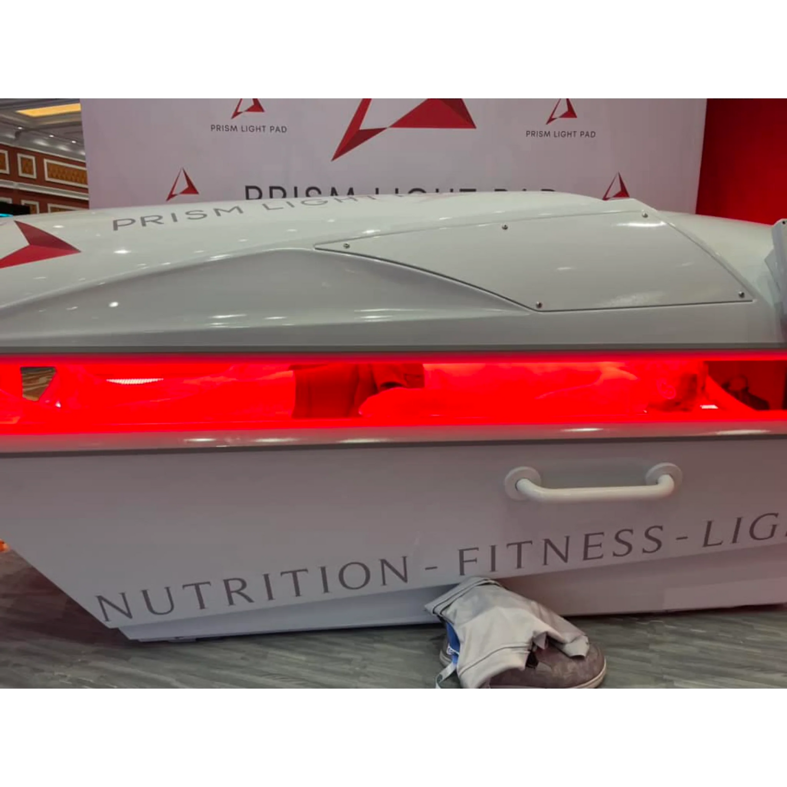 Prism Light Pod Full-Body Red Light Therapy Bed – pod open with red light on a lit stage