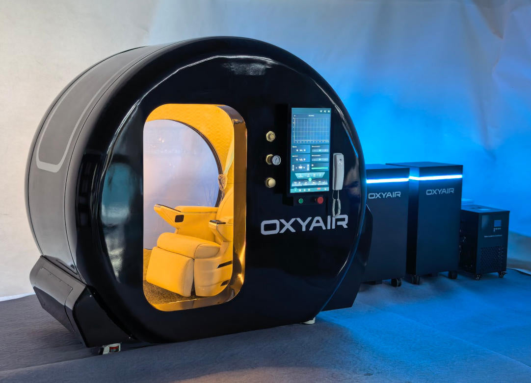 Oxyair OLV-YZD01 black hard-shell sitting chamber with leather seat visible through the door, shown beside its supporting equipment units