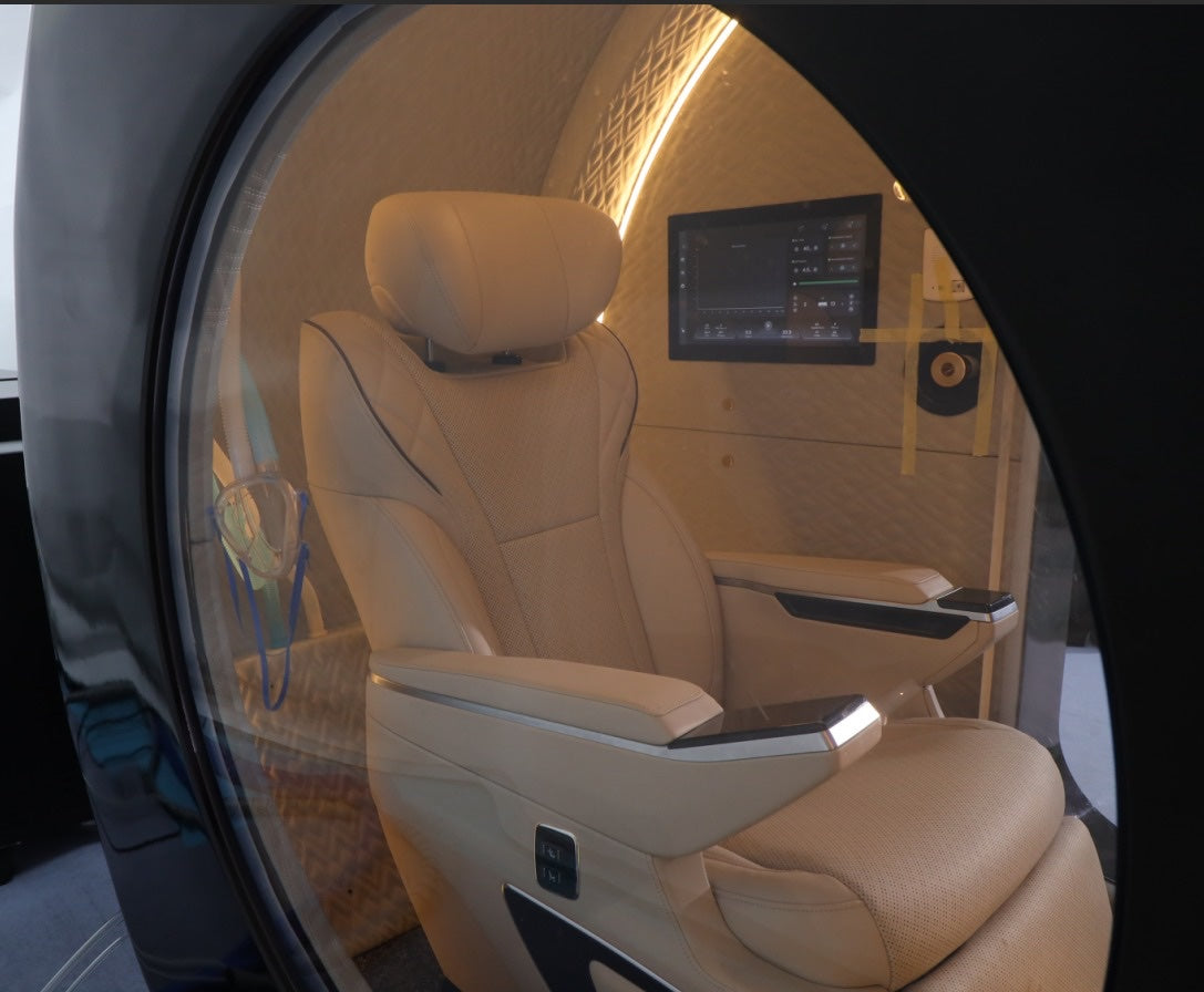Oxyair OLV-YZD01 interior seen through the round side window, with leather seat, touch screen and oxygen mask